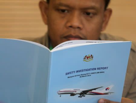 A family member reads an MH370 briefing report before a closed door meeting in Putrajaya, Malaysia July 30, 2018. REUTERS/Sadiq Asyraf