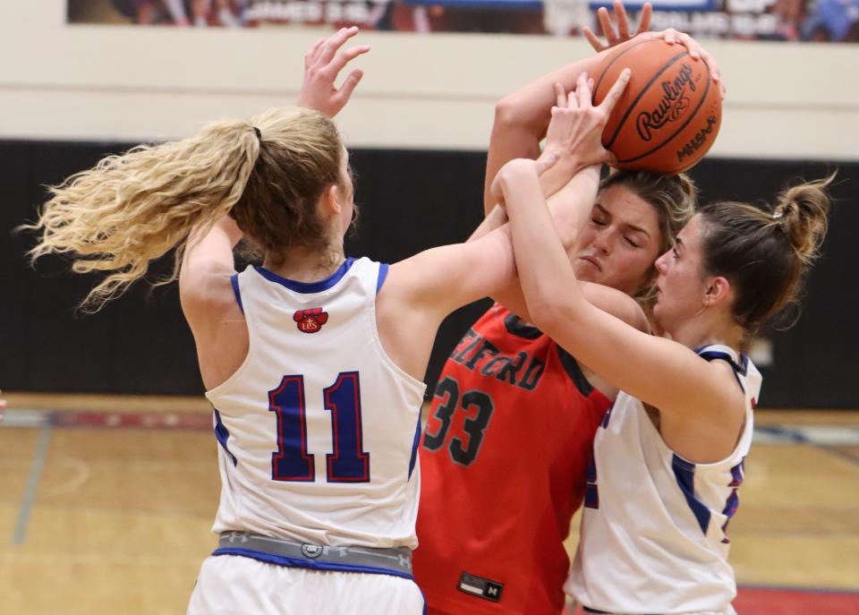 Victoria Gray battles two Lenawee Christian plays for a rebound during Bedford's 42-21 victory on Martin Luther King Day Monday.