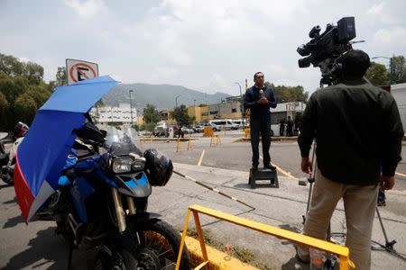 A journalist does a dispatch during the second judicial hearing of Javier Duarte, former governor of Mexican state Veracruz, outside a court on the outskirts of Mexico City, Mexico, July 22, 2017. REUTERS/Edgard Garrido