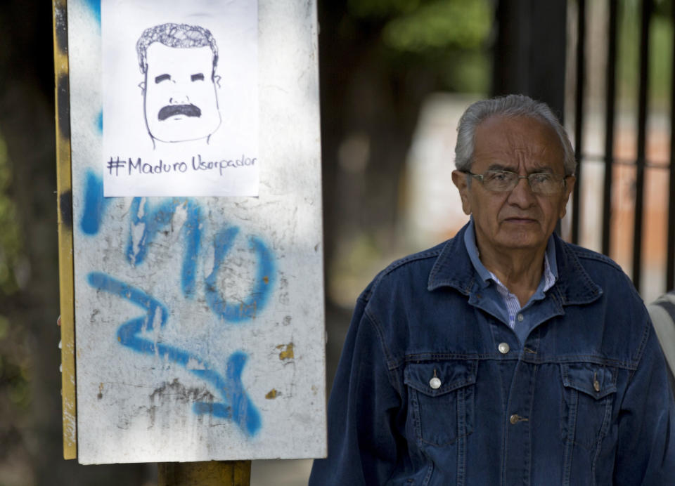 A drawing of Venezuelan President Nicolas Maduro and the Spanish message "Maduro usurper" hangs on a telephone booth on the day Maduro is sworn in for a second term in Caracas, Venezuela, Thursday, Jan. 10, 2019. Maduro's second, six-year term starts amid international calls for him to step down and a devastating economic crisis. (AP Photo/Fernando Llano)