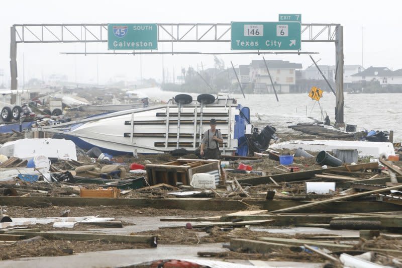 Galveston resident Calvin Wehrle (C) makes his way back to his vehicle after checking out debris that came onto I-45 North from Hurricane Ike in Galveston, Texas on September 13, 2008. File Photo by Aaron M. Sprecher/UPI