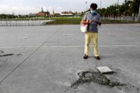 A man stands near the place where a plaque placed by Thai pro-democracy protesters near the Grand Palace in Bangkok that declared that Thailand belongs to the people and not the king, after the plaque was removed according to police, in Bangkok