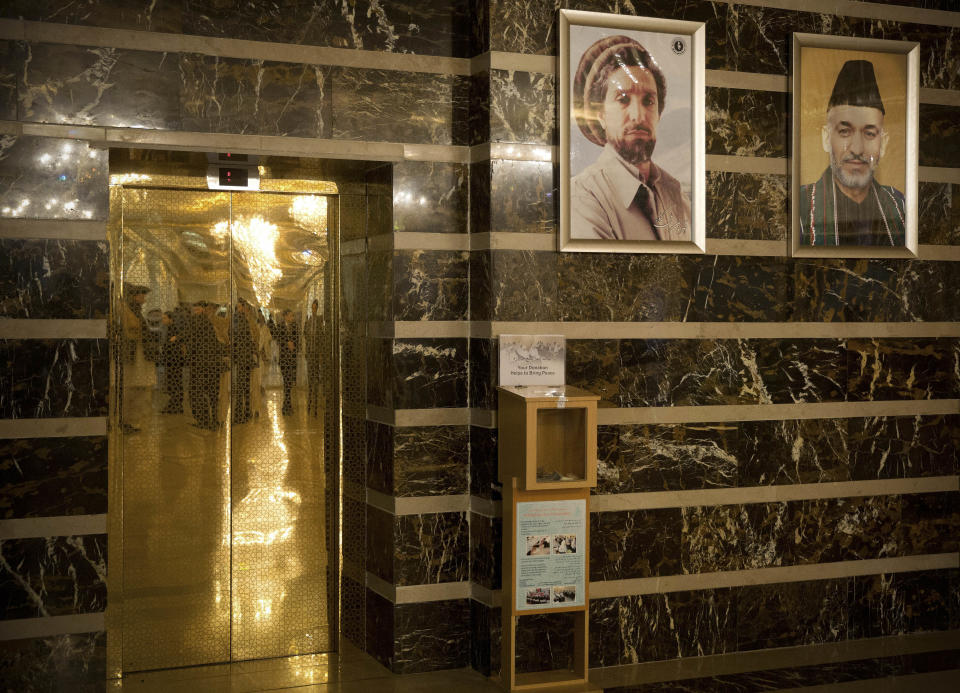 In this Wednesday, May 26, 2014 photo, a picture of Afghan President Hamid Karzai, right, hangs next to Afghan political and military leader Ahmad Shah Massoud at a luxury hotel in Kabul, Afghanistan. Afghans go to the polls April 5, 2014 to choose a new president, and that in itself may one day be considered Karzai’s greatest achievement. (AP Photo/Anja Niedringhaus)