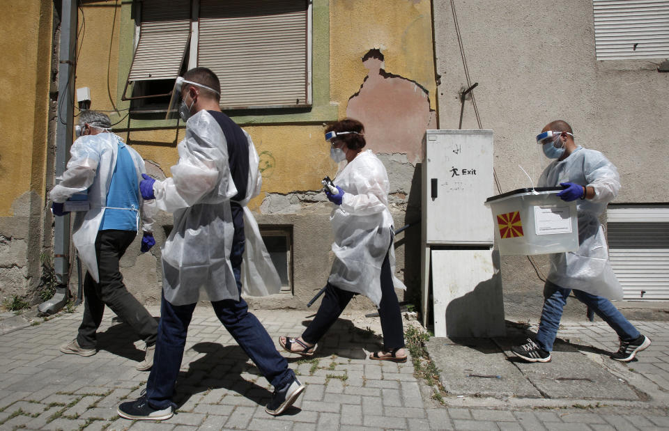 Members of a special election team with a ballot box and voting material make their way visiting voters who have tested positive for COVID-19 or are in self-isolation, in Skopje, North Macedonia, Monday, July 13, 2020. North Macedonia holds its first parliamentary election under its new country name this week, with voters heading to the polls during an alarming spike of coronavirus cases in the small Balkan nation. Opinion polls in the run-up to Wednesday’s vote indicate a close race between coalitions led by the Social Democrats and the center-right opposition VMRO-DPMNE party. (AP Photo/Boris Grdanoski)