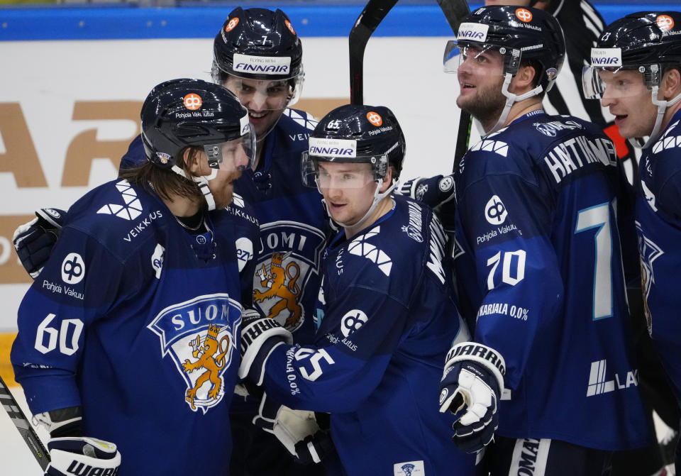 Finland's Sekari Manninen, centre, celebrates with his teammates after scoring his side's second goal during the Channel One Cup ice hockey match between Russia and Finland in Moscow, Russia, Sunday, Dec. 19, 2021. (AP Photo/Alexander Zemlianichenko)