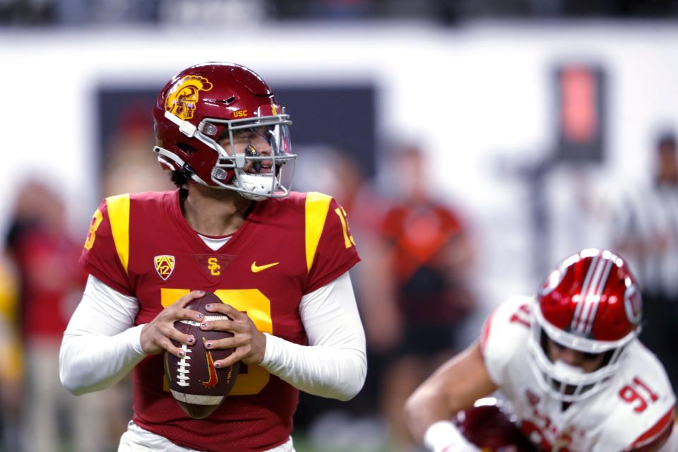 Southern California quarterback Caleb Williams (13) looks for an open receiver during the first half of the team's Pac-12 Conference championship NCAA college football game against Utah on Friday, Dec. 2, 2022, in Las Vegas. Utah defensive end Gabe Reid (91) is at right. (AP Photo/Steve Marcus)