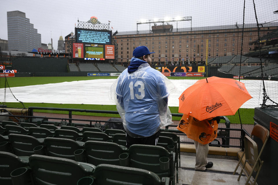 Charlie Slaybaugh of Kansas City, Mo., waits out a rain delay before a baseball game between the Baltimore Orioles and the Kansas City Royals, Wednesday, April 3, 2024, in Baltimore. (AP Photo/Nick Wass)