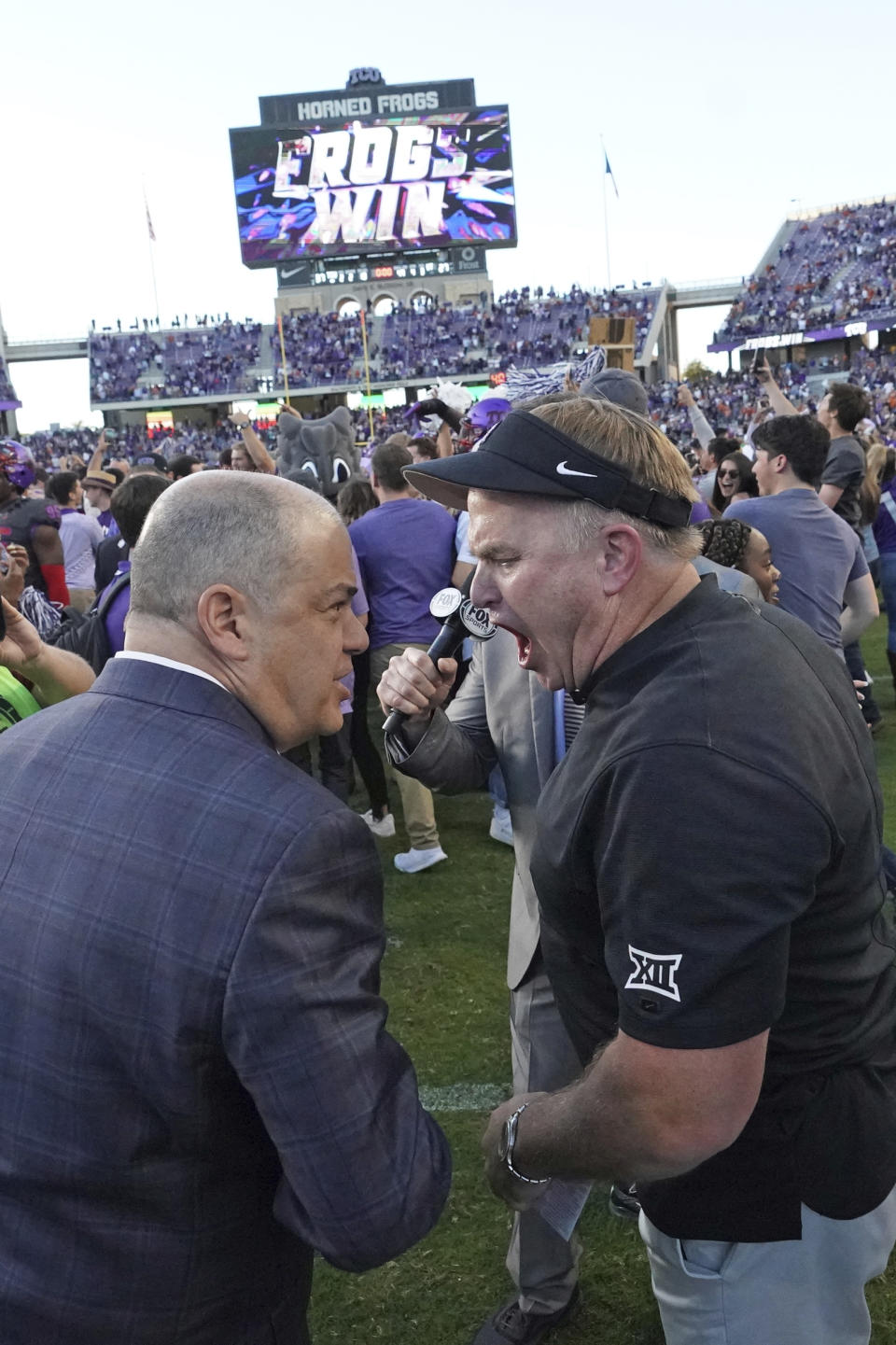 TCU head coach Gary Patterson, right, talks with a member of the media on the field after an NCAA college football game against Texas in Fort Worth, Texas, Saturday, Oct. 26, 2019. (AP Photo/Louis DeLuca)