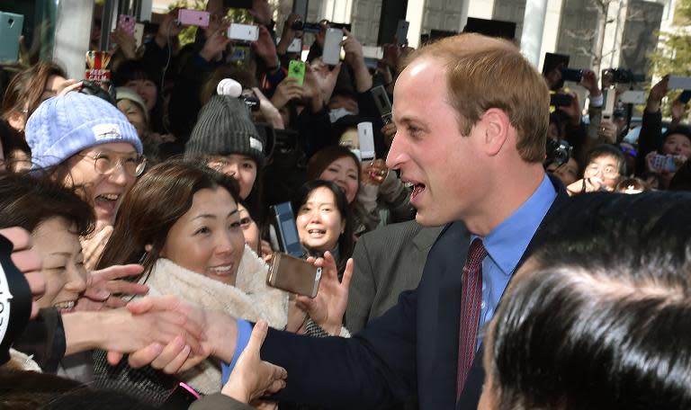 Britain's Prince William is greeted by well-wishers upon his arrival at a bookshop in Tokyo on February 28, 2015 to launch a public exhibition