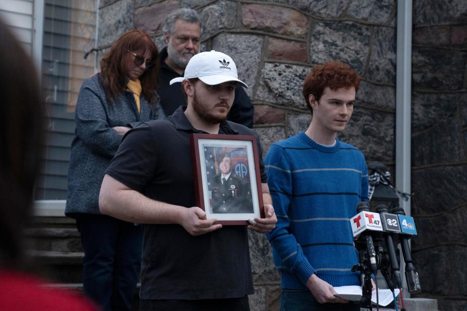 Aidan Solinas, at right, reads a statement about his brother David in front of his family's home in Oradell on Friday. Sgt. David Solinas Jr., 23, was killed during a medi-vac training mission near a base in Kentucky.