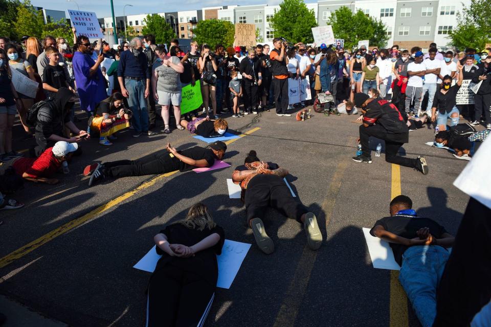 Protestors lay on the ground as if being detained by police during a demonstration in Sioux Falls, S.D. 