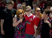 Owen Richards (C), who lost his brother, uncle and grandfather in the Tunisia attacks, observes a minute's silence with his mother Suzy Evans (2nd L) outside Walsall football club in central England, on July 3, 2015