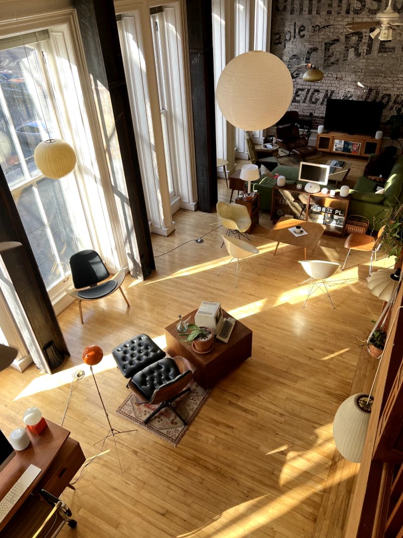 View from overhead of seating, dining, living areas of loft with hardwood floor.