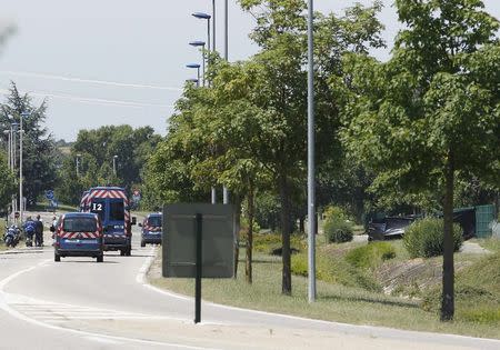 French Gendarmes and rescue forces stand next to a black plastic sheet (R) outside a gas company site at the industrial area of Saint-Quentin-Fallavier, near Lyon, France, June 26, 2015. REUTERS/Emmanuel Foudrot