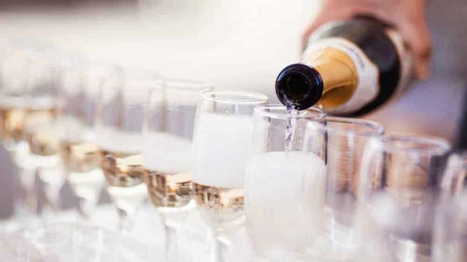 Champagne poured into a row of flutes