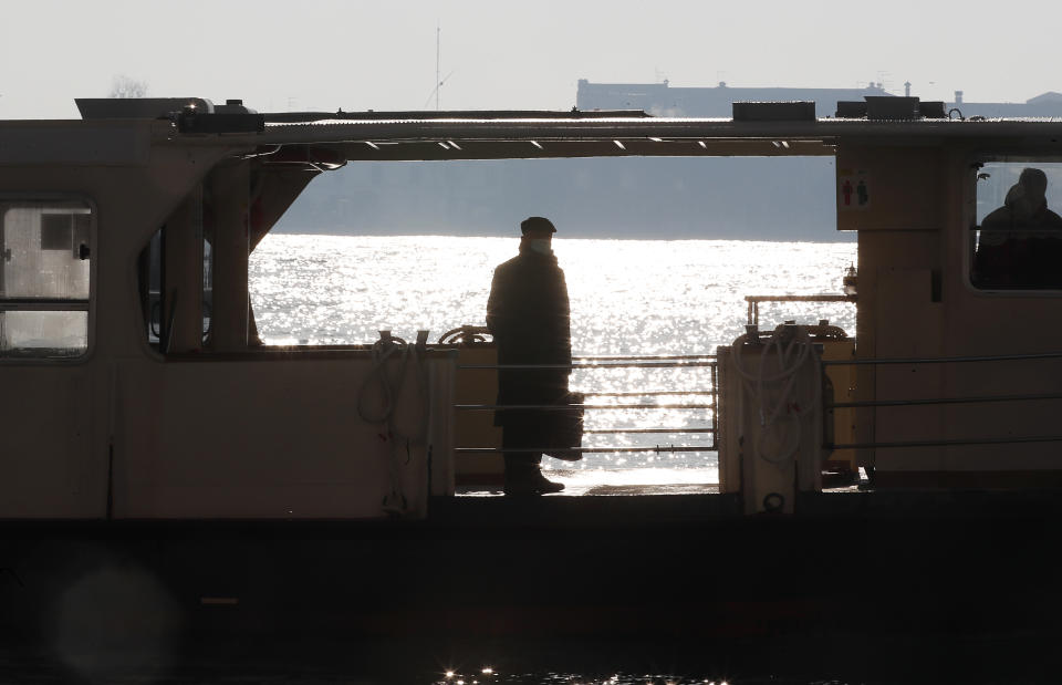 A man stands on the Vaporetto ferry boat in Venice, Italy, Saturday, Jan. 30, 2021. (AP Photo/Antonio Calanni)