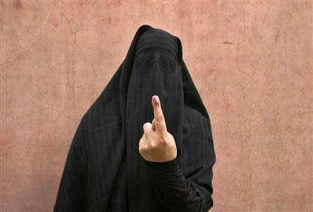 A veiled Muslim woman shows her ink-marked finger after voting outside a polling station in Doda district, north of Jammu, April 17, 2014. Around 815 million people have registered to vote in the world's biggest election - a number exceeding the population of Europe and a world record - and results of the mammoth exercise, which concludes on May 12, are due on May 16. REUTERS/Mukesh Gupta