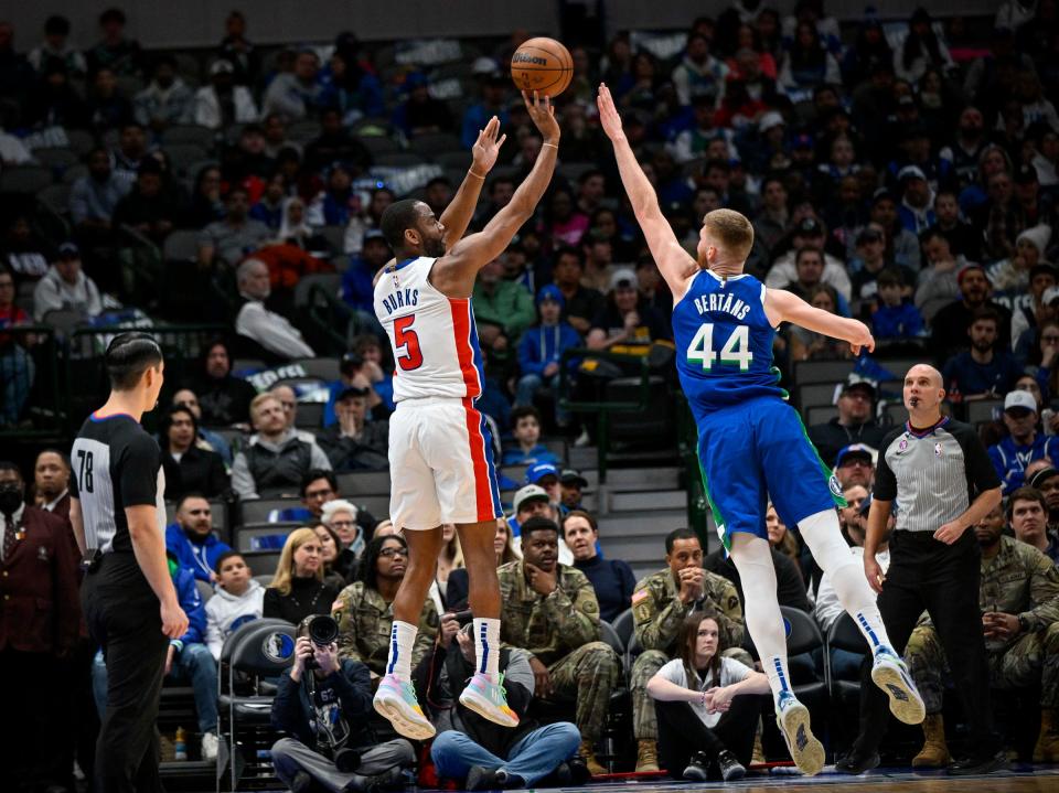 Pistons guard Alec Burks makes a 3-point shot over Mavericks forward Davis Bertans during the second quarter of the Pistons' 111-105 loss on Monday, Jan. 30, 2023, in Dallas.