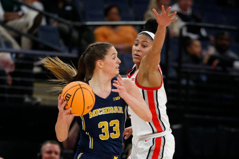 Michigan forward Emily Kiser (33) looks to pass the ball as Ohio State guard Taylor Thierry, right, defends in the first half of an NCAA college basketball game at the Big Ten women's tournament Friday, March 3, 2023, in Minneapolis. (AP Photo/Bruce Kluckhohn)