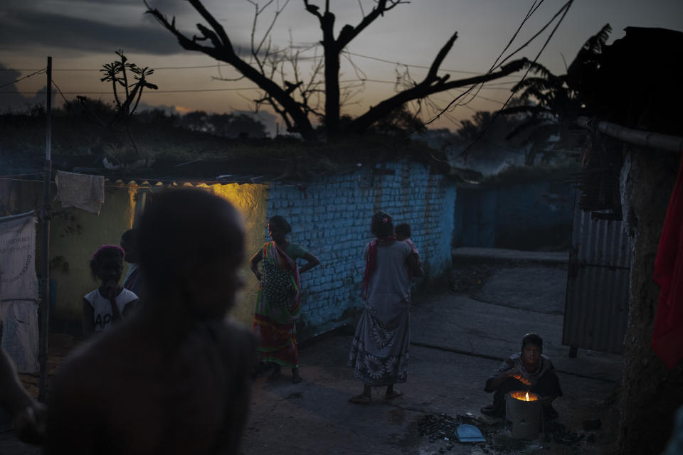 A woman ignites a coal hearth in a village where coal workers live in Dhanbad, an eastern Indian city in Jharkhand state, Sept. 24, 2021. No country will see energy needs grow faster in coming decades than India, and even under the most optimistic projections part of that demand will have to be met with dirty coal power — a key source of heat-trapping carbon emissions. (AP Photo/Altaf Qadri)