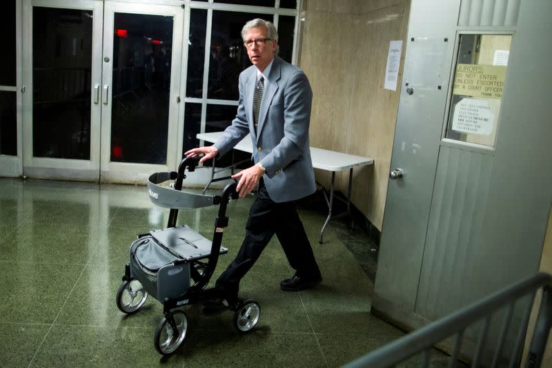 A man pushes out of the courtroom the chair used by film producer Harvey Weinstein after a verdict during the ongoing sexual assault trial of at New York Criminal Court in the Manhattan borough of New York City, New York