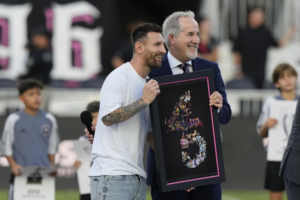 El argentino Lionel Messi, del Inter Miami, posa con Jorge Mas, dueño administrativo del club, quien le entregó un reconocimiento por 45 trofeos internacionales, antes del partido del sábado 20 de julio de 2024, ante el Fire de Chicago en Fort Lauderdale, Florida (AP Foto/Lynne Sladky)