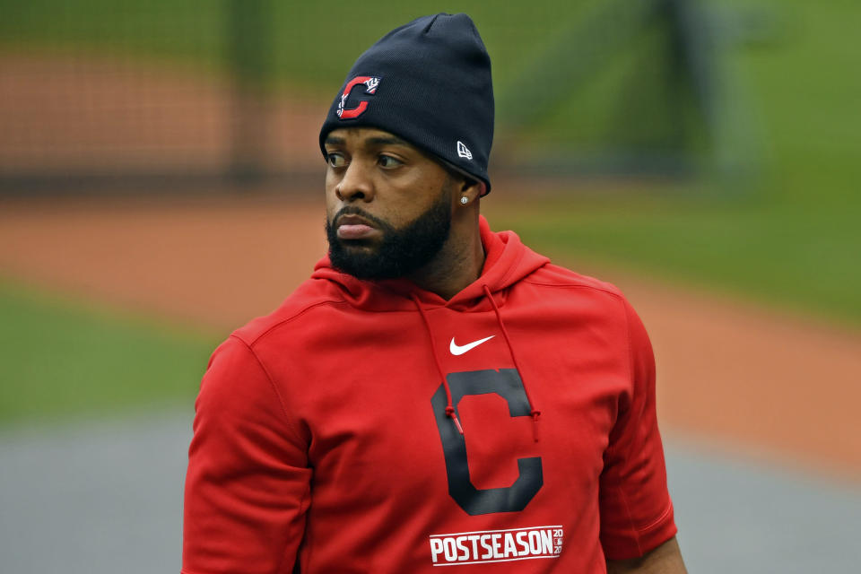 FILE- In this Sept. 29, 2020, file photo, Cleveland Indians' Carlos Santana exits the batting cage before Game 1 of an American League wild-card baseball series against the New York Yankees in Cleveland. The Cleveland Indians have declined contract options on Brad Hand and first baseman Carlos Santana for next season, decisions that will initially cut $27 million from the team's payroll. (AP Photo/David Dermer, File)