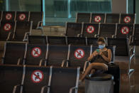 A passenger sits at Barcelona airport in Barcelona, Spain, Tuesday, June 30, 2020. The European Union on Tuesday is announcing a list of nations whose citizens will be allowed to enter 31 European countries. As Europe’s economies reel from the impact of the coronavirus, southern EU countries like Greece, Italy and Spain are desperate to entice back sun-loving visitors and breathe life into their damaged tourism industries. (AP Photo/Emilio Morenatti)