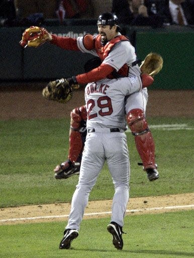 Boston Red Sox catcher Jason Varitek leaps into the arms of pitcher Keith Foulke (29) after the Red Sox beat the St. Louis Cardinals 3-0 to sweep the World Series on Oct. 27, 2004, in St. Louis.