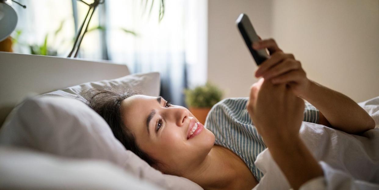 woman in her bed checking phone in the morning