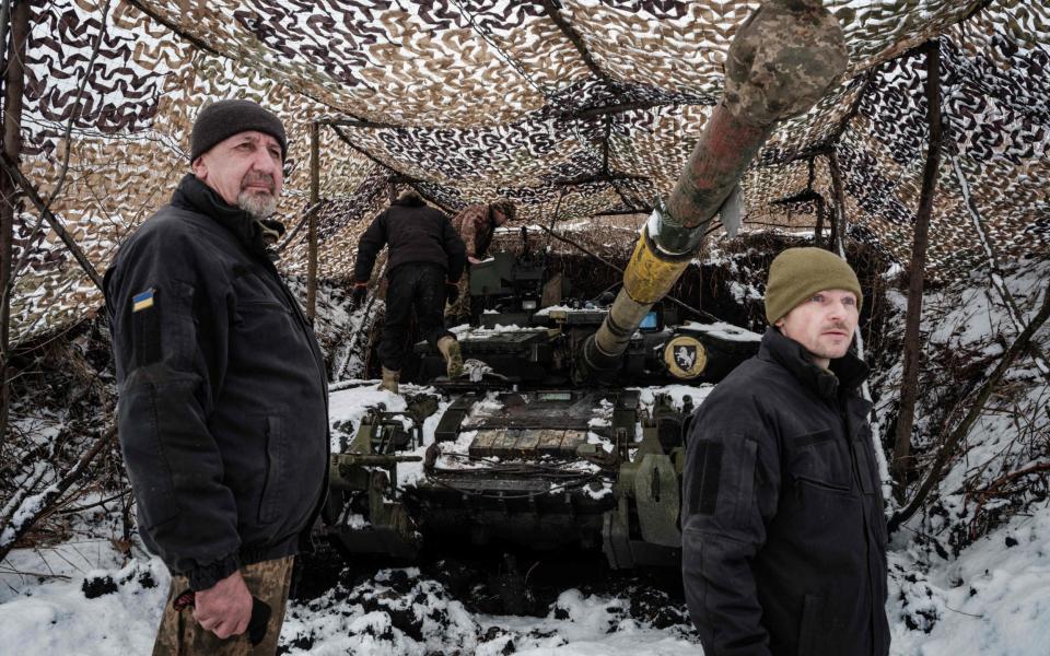 Ukrainian servicemen stand with their tank - YASUYOSHI CHIBA / AFP