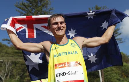 Athletics - Gold Coast 2018 Commonwealth Games - Men's 20km Race Walk Final - Currumbin Beachfront - Gold Coast, Australia - April 8, 2018. Gold medallist Dane Bird-Smith of Australia celebrates his win with the Australian flag. REUTERS/Paul Childs