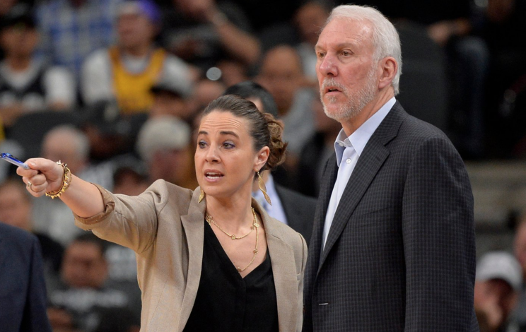 Becky Hammon asiste a Gregg Popovich durante un partido.