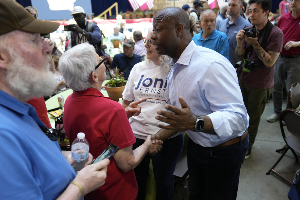 Republican presidential candidate South Carolina Sen. Tim Scott talks with an audience member during U.S. Sen. Joni Ernst's Roast and Ride, Saturday, June 3, 2023, in Des Moines, Iowa. (AP Photo/Charlie Neibergall)