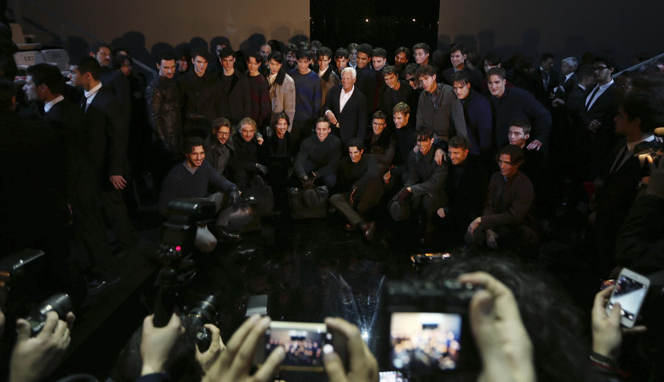 Italian fashion designer Giorgio Armani, center, poses with models at the end of his Giorgio Armani men's Fall-Winter 2014 fashion show, part of the Milan Fashion Week, unveiled in Milan, Italy, Tuesday, Jan.14, 2014. (AP Photo/Luca Bruno)