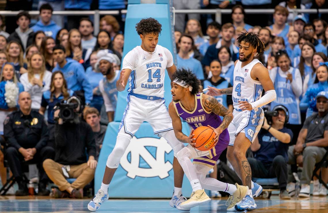 North Carolina’s Donovan ‘Puff’ Johnson (14) and R.J. Davis (4) trap James Madison’s Vado Morse (4) in the second half on Sunday, November 20, 2022 at the Smith Center in Chapel Hill, N.C.