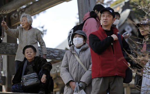 Japanese residents gather on higher ground after a new tsunami warning was issued along the coast in Sendai on March 14, 2011. The tsunami alert has since been lifted