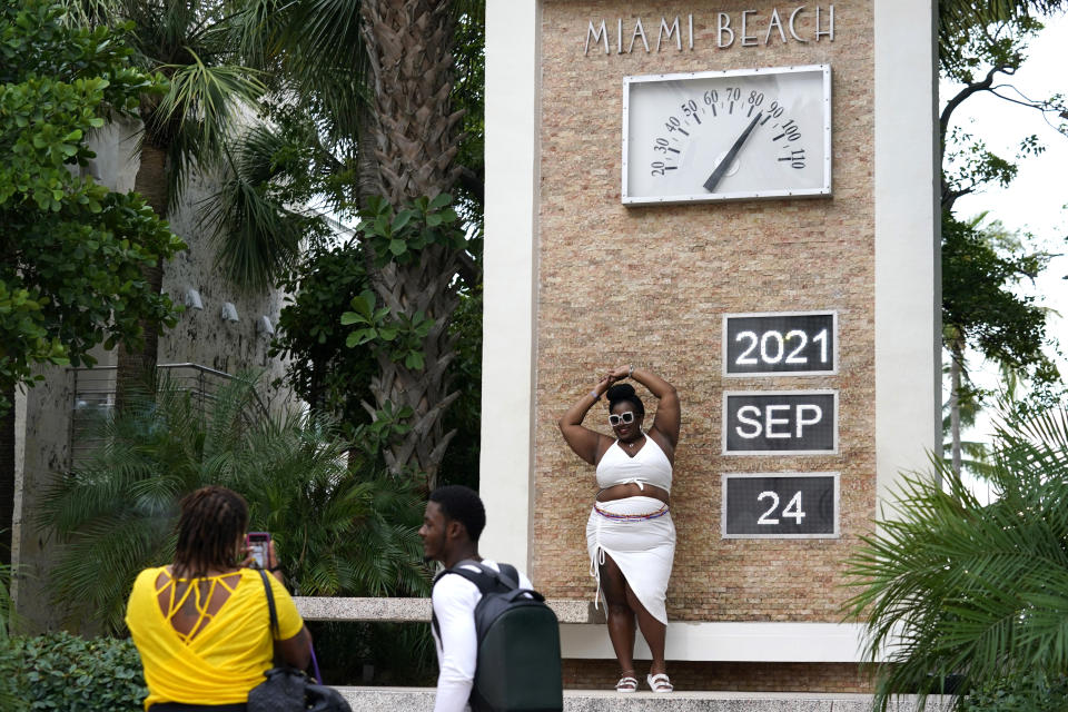 Danielle Wright, visiting from Roanoke, Va., poses for a friend taking a photograph along Ocean Drive, Friday, Sept. 24, 2021, in Miami Beach, Fla. For decades, this 10-block area has been one of the most glamorized spots in the world, made cool by TV shows like Miami Vice, where the sexiest models gathered at Gianni Versace's ocean front estate and rappers wrote lines about South Beach's iconic Ocean Drive. (AP Photo/Lynne Sladky)