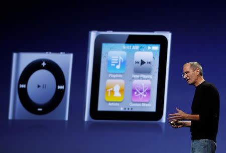 FILE PHOTO: Apple Chief Executive Steve Jobs speaks on stage with images of the iPod Shuffle (L) and iPod Nano projected on screen at Apple's music-themed September media event in San Francisco, California September 1, 2010. REUTERS/Robert Galbraith/File Photo