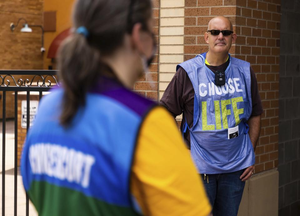 Anti-abortion protester Tom Schaer, right, stands outside WE Health Clinic, Thursday, July 7, 2022, in Duluth, Minn. Protesters like Schaer are often seen outside the clinic during days when abortions are taking place. (AP Photo/Derek Montgomery)