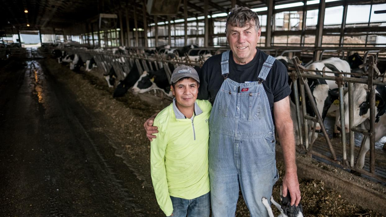 Roberto Tecpile (left), a farm worker from Veracruz, Mexico, and John Rosenow (right), owner of Rosenholm dairy farm, pose for a portrait at the farm in Cochrane, Wisconsin, in October. (Photo: Caroline Yang for HuffPost)