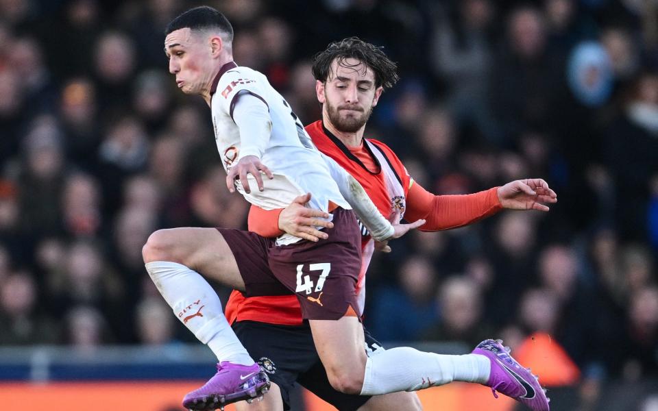 Manchester City's English midfielder #47 Phil Foden fights for the ball with Luton Town's Welsh defender #04 Tom Lockyer during the English Premier League football match between Luton Town and Manchester City at Kenilworth Road