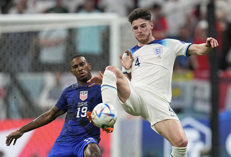 England's Declan Rice, right, and Haji Wright of the United States fight for the ball during the World Cup group B soccer match between England and The United States, at the Al Bayt Stadium in Al Khor, Qatar, Friday, Nov. 25, 2022. (AP Photo/Abbie Parr)