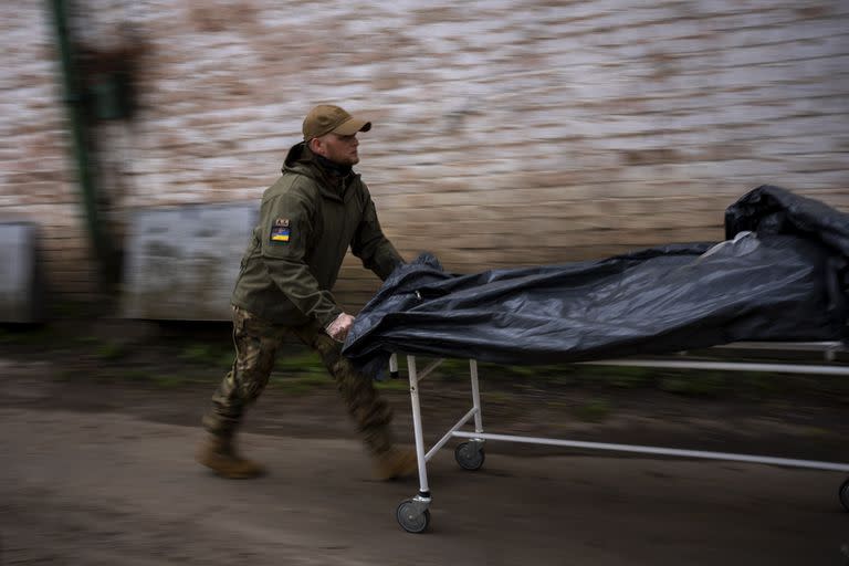 Darrell Loveless trabaja trasladando cadáveres de camiones refrigerados a la morgue en Bucha, en las afueras de Kiev, el lunes 25 de abril de 2022. 