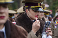 FILE - A military cadet refreshes her lipstick before the National Day parade in Bucharest, Romania, Friday, Dec. 1, 2023. (AP Photo/Vadim Ghirda, File)