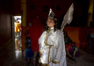 An actor dressed as a demon from Mount Gethsemane takes a break inside a home as he partakes in the reenactment of Jesus' crucifixion in a "Via Crucis," or Stations of the Cross procession during Holy Week in the indigenous neighborhood of Monimbo in Masaya, Nicaragua, Thursday, April 17, 2014. (AP Photo/Esteban Felix)