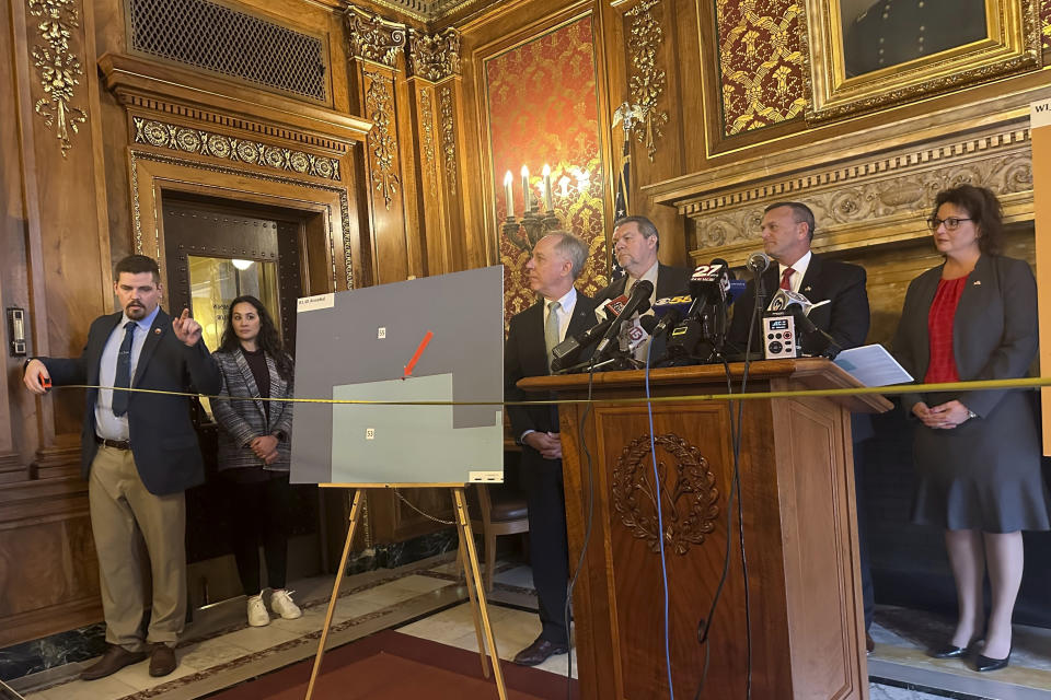 Wisconsin Republican Rep. Nate Gustafson holds a tape measure in front of fellow Republicans to demonstrate how far he was drawn out of his legislative district under a map proposed by Democratic Gov. Tony Evers during a Capitol news conference Wednesday, Jan. 24, 2024, in Madison, Wis. Republicans proposed a bill making changes to the Evers map. (AP Photo/Scott Bauer)