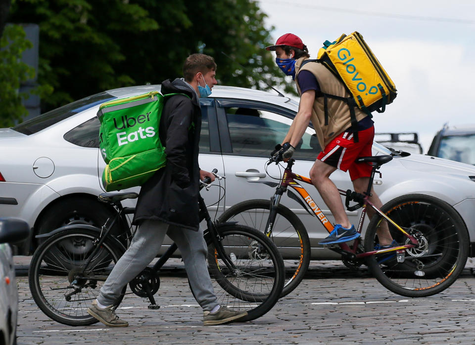 Uber Eats and Glovo delivery couriers with bicycles cross a street amid the outbreak of the coronavirus disease (COVID-19) in central Kiev, Ukraine May 13, 2020. REUTERS/Gleb Garanich