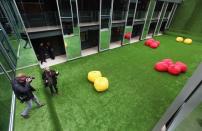 A photographer shoots pictures in a courtyard of THE OUT NYC in New York. Known as the Great Lawn, this AstroTurf-covered expanse is one of the three courtyards that invite air and light into the hotel.