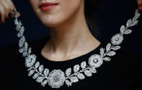 A employee holds a Belle Epoque diamond and emerald neckace during an auction preview at Christie's in London March 29, 2012. The necklace was estimated to fetch between $1.3 million to $1.5 million.